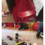 Auf dem oberen Bild hält eine Person einen roten Rucksack. Auf dem unteren Bild ist der Inhalt des Rucksacks - verschiedene kleine Gegenstände, darunter eine Bierflasche, eine Tasse, ein Spielzeug und ein Kartenspiel - auf dem Boden zwischen den Beinen der Person verteilt.