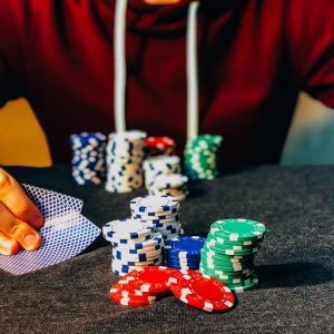 Eine Person, die mit Karten und Chips pokert.
