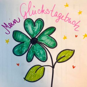 Eine handgezeichnete grüne Blume mit einer schwarzen Mitte und zwei Blättern. Der deutsche Text darüber lautet Mein Glückstagebuch in rosa und blau. Kleine gelbe und orangefarbene Sterne verzieren den Hintergrund.