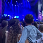 Joanna hät einen Jungen auf dem Arm, damit er die Bühne bei den Kurparkclassix besser sehen kann.