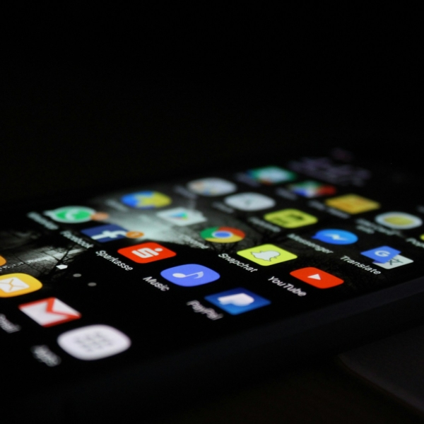 Ein Handy leuchtet im Dunklen. Die Apps sind zu sehen.